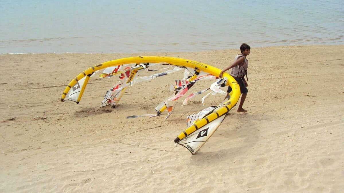 Where to Get Your Kite or Wing Repaired in the UK - Child pulling a colorful kite on a sandy beach.