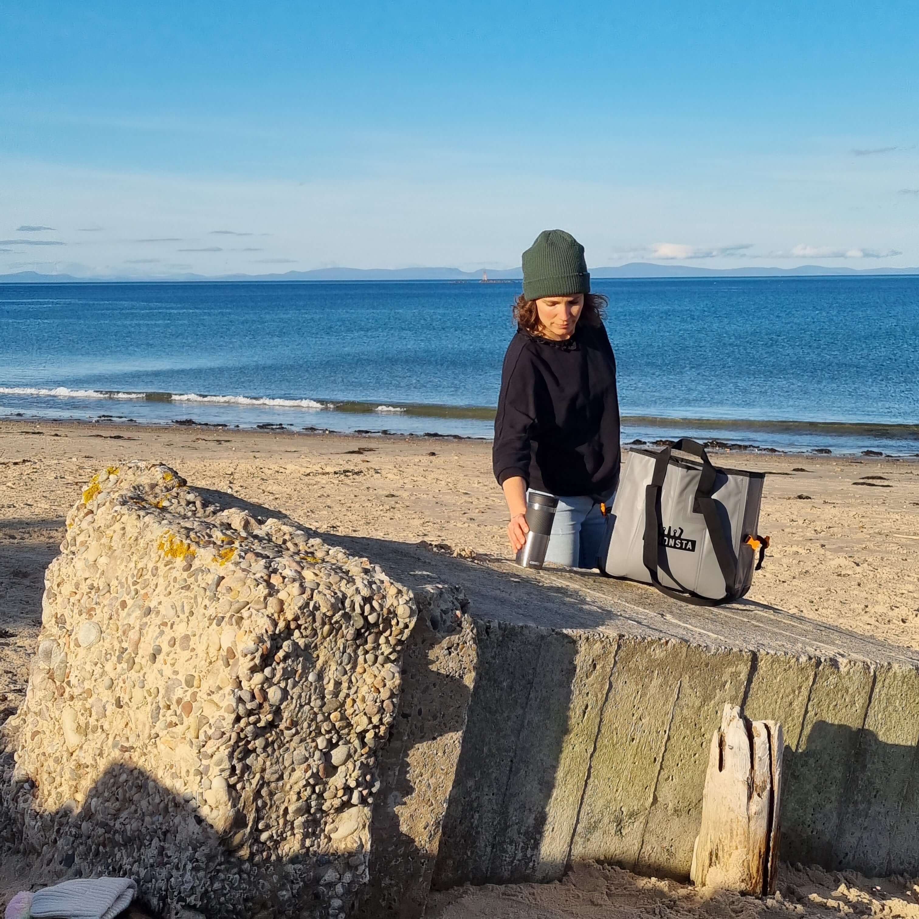 C-Monsta Mini Split Bag | Compact Wet & Dry Gear Bag on the beach with a person preparing for water activities.