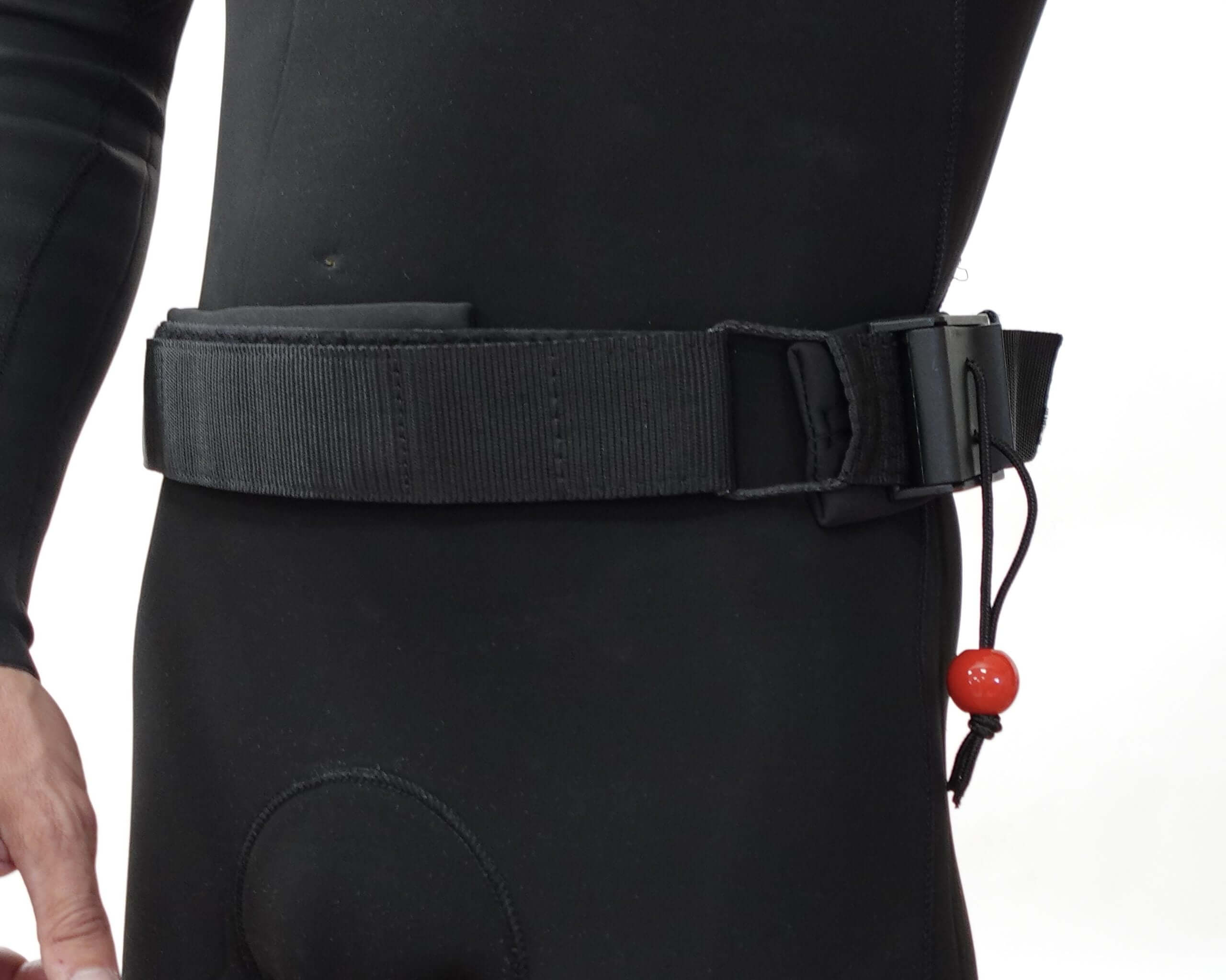 Wingfoil board waist leash attached to a person's wetsuit, showcasing the design and functionality for foil board safety.