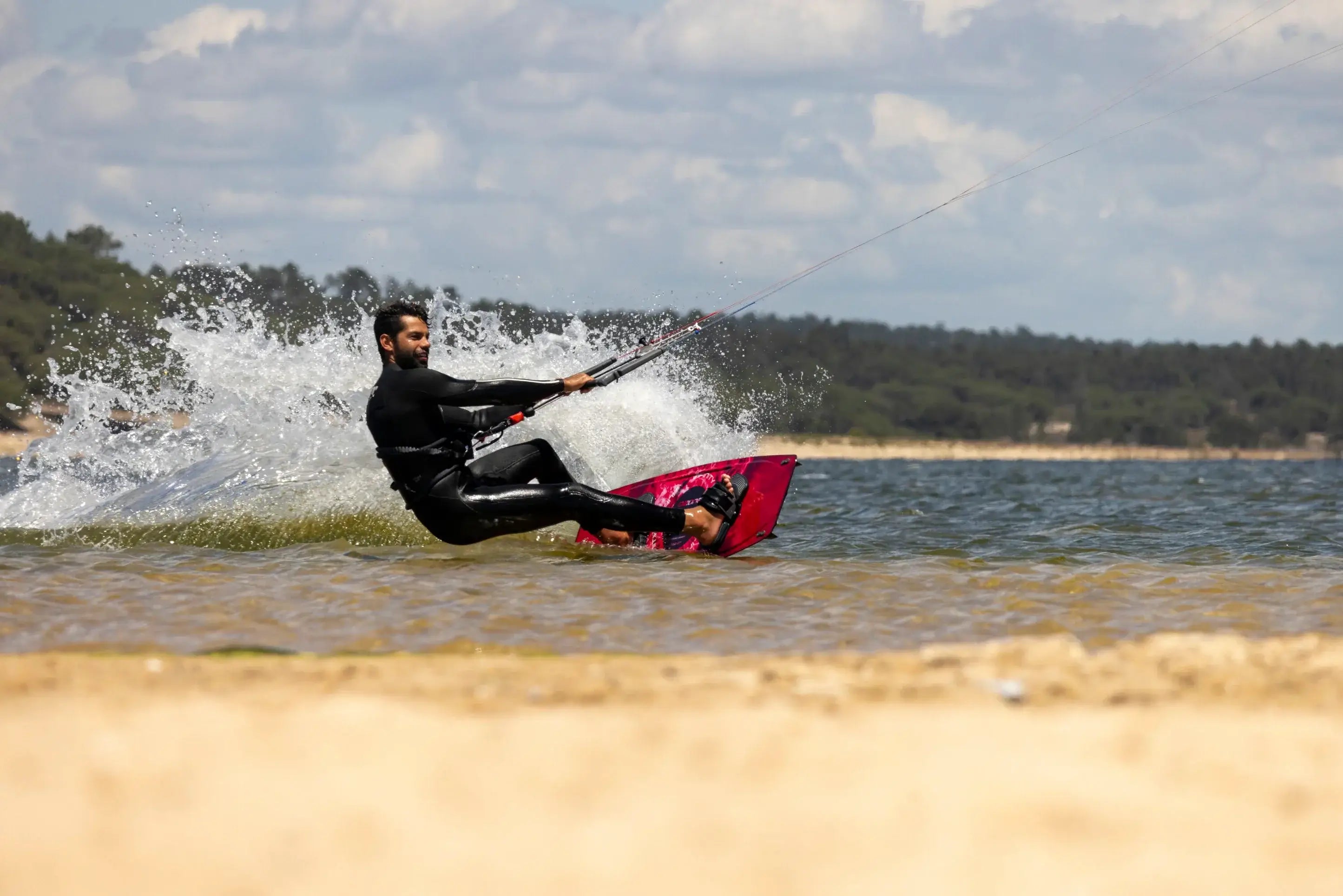 Rider on the Ozone Infinity Twintip V4 – Lightwind Freeride gliding over water with a spray of waves