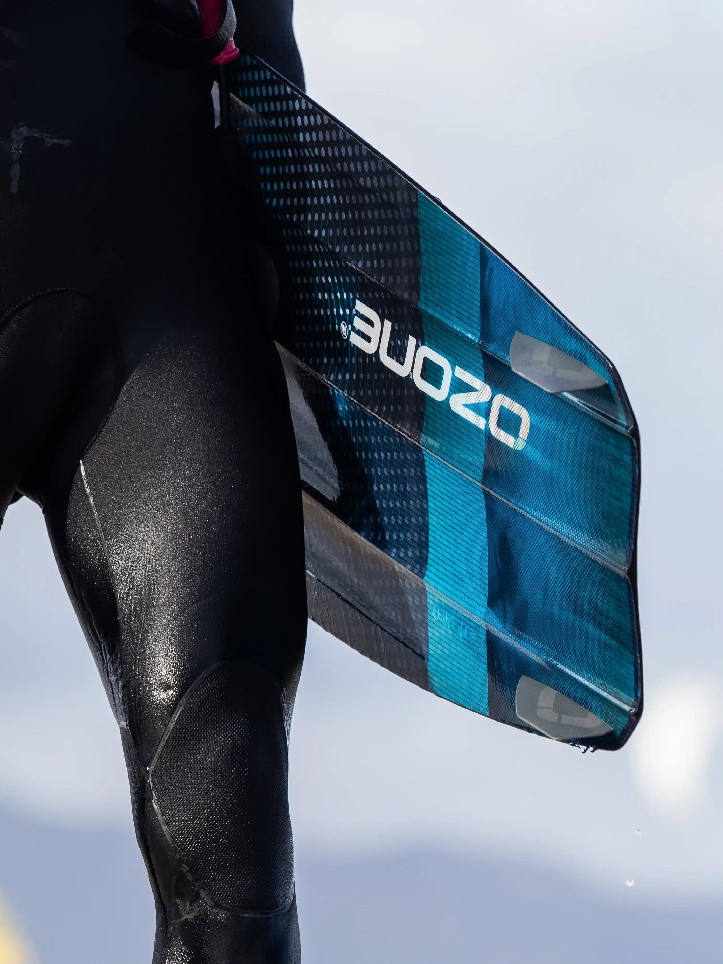 Ozone Torque V4 Twintip – Big Air, Freeride & Freestyle surfboard held by rider in wetsuit on the beach.