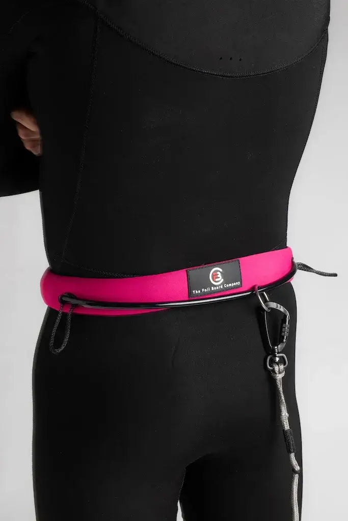 FBC Wing Waist Leash V2 RAD Edition in pink worn by a person, showcasing its design and attachment features for wingfoiling.