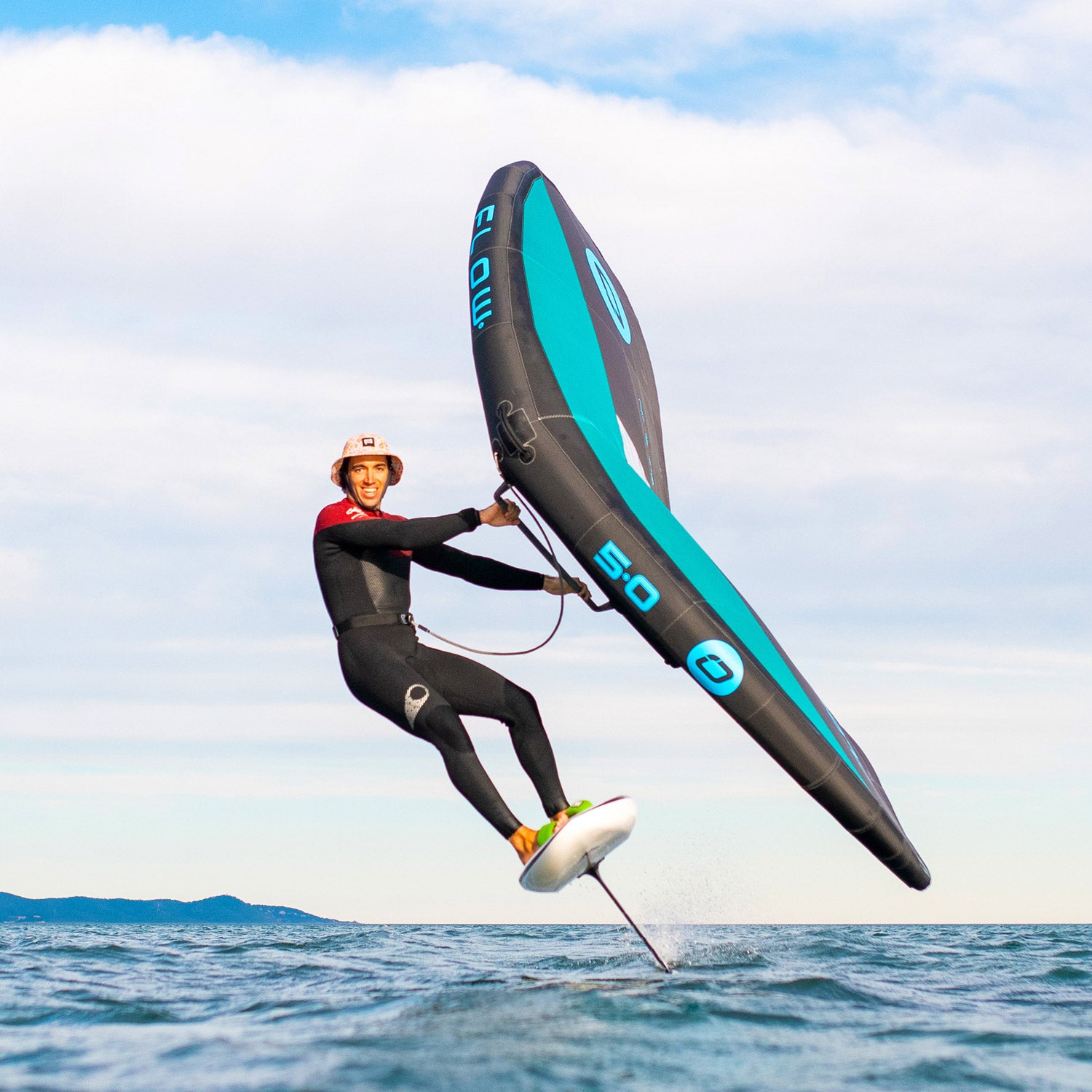 A rider using the Ozone Flow V2 | Wing while foiling over water, showcasing its performance and design.