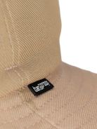 Close-up image of the unique texture and brand tag on a stylish beige bucket hat.