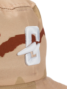 Close-up of the embroidered logo on a camo bucket hat in natural colors.