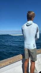 Person wearing Convertible Neo-Front Rash Guard, enjoying warm-water protection on a boat.