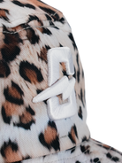 Close-up of a stylish cap featuring a leopard print design and a distinctive white logo emblem.