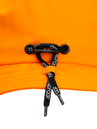 Close-up of the adjustable fit system on the Bangproof Helmet V2, featuring orange fabric and black retention straps.