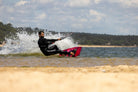 Rider on the Ozone Infinity Twintip V4 – Lightwind Freeride gliding over water with a spray of waves