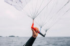 Ozone Pocket Rocket V1 – Parawing Foiling Freedom showcased with a hand gripping the control lines on a windy day.