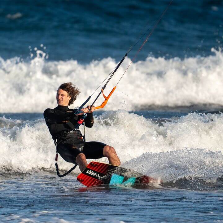 Shinn Monker Kiteboard 2025 – Smooth Control & Comfort in action on the waves with a kite surfer.