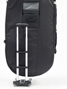 A black wing foil travel bag with wheels and a telescoping handle, designed for transporting board sports equipment.