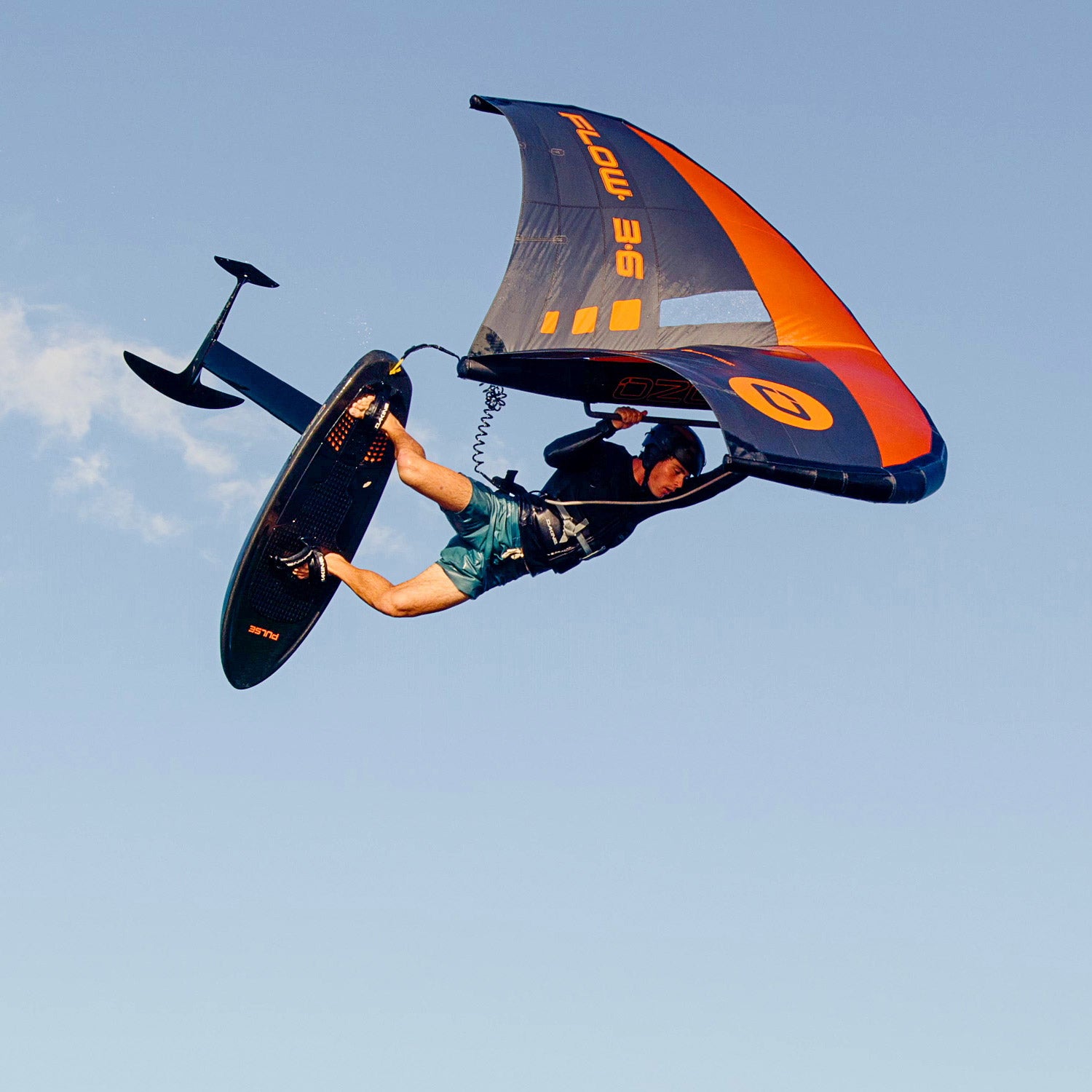 Ozone Flow V2 | Wing being used by a rider performing aerial maneuvers against a clear sky.