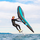A rider using the Ozone Flow V2 | Wing while foiling over water, showcasing its performance and design.